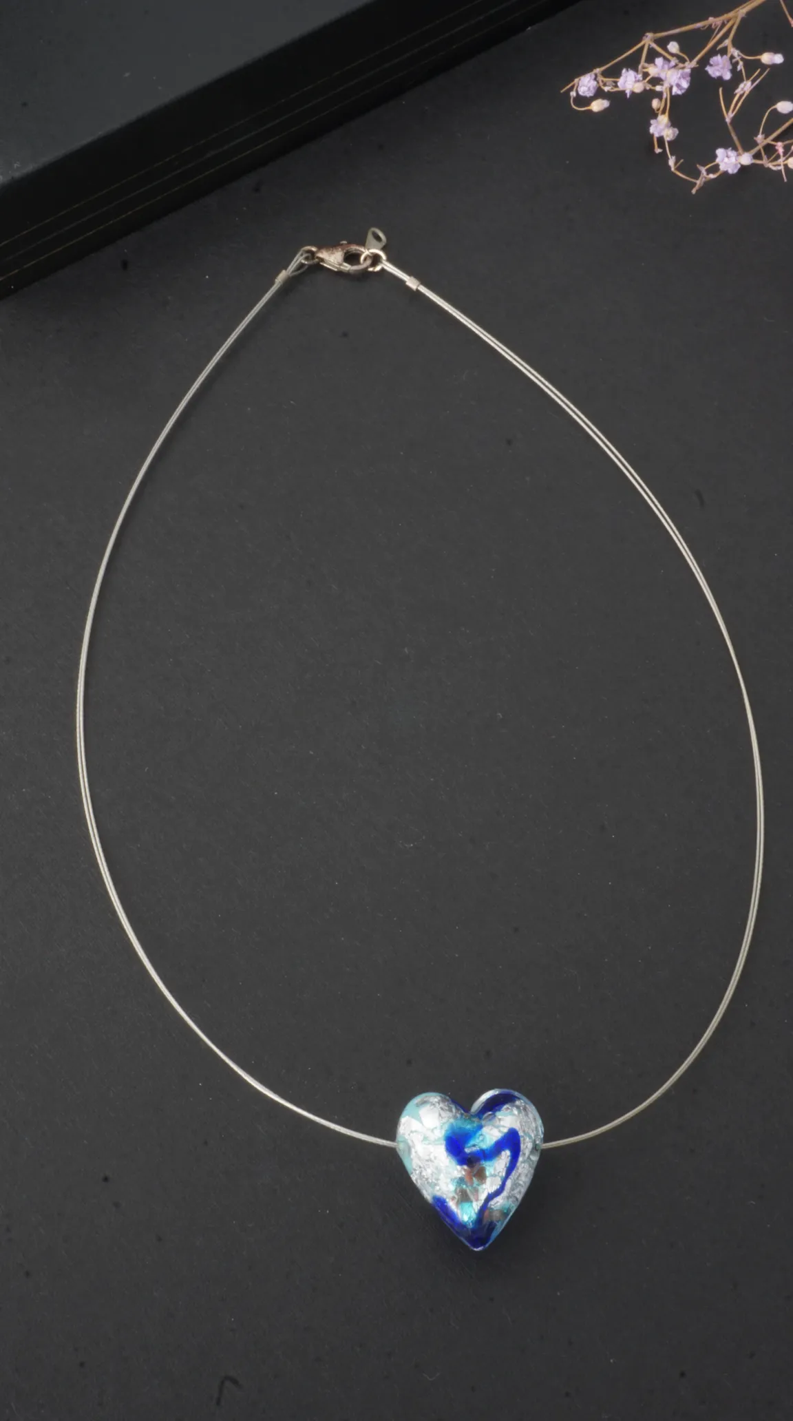 Vintage blue and silver swirled art glass heart pendant necklace on a delicate silver-toned wire.