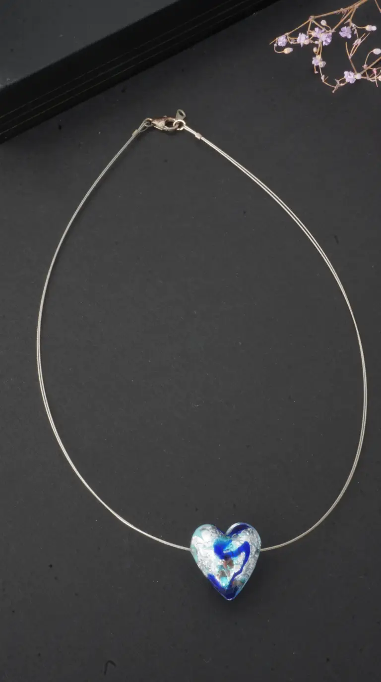 Vintage blue and silver swirled art glass heart pendant necklace on a delicate silver-toned wire.