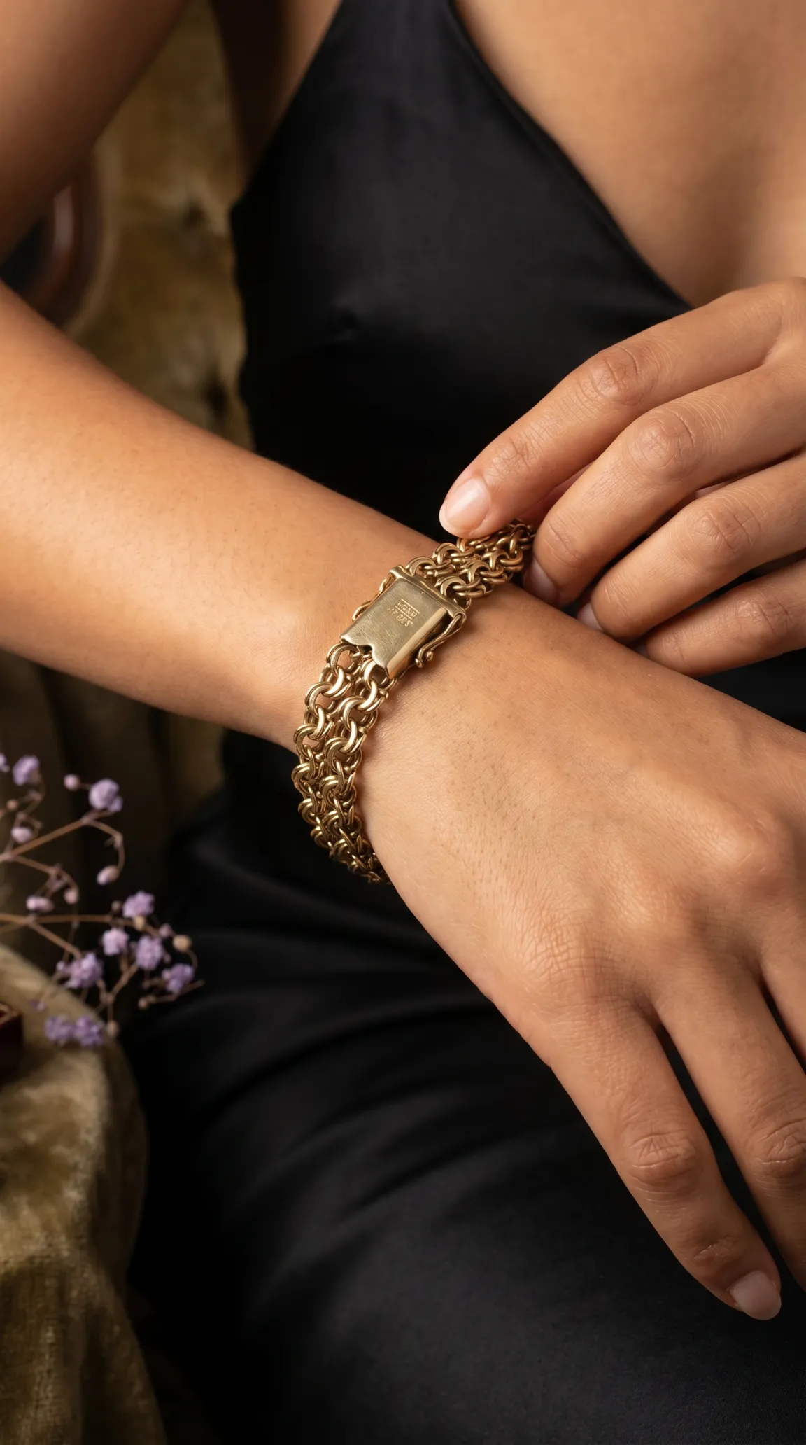 Vintage gold wide linked bracelet with engraved box clasp on a person's wrist.