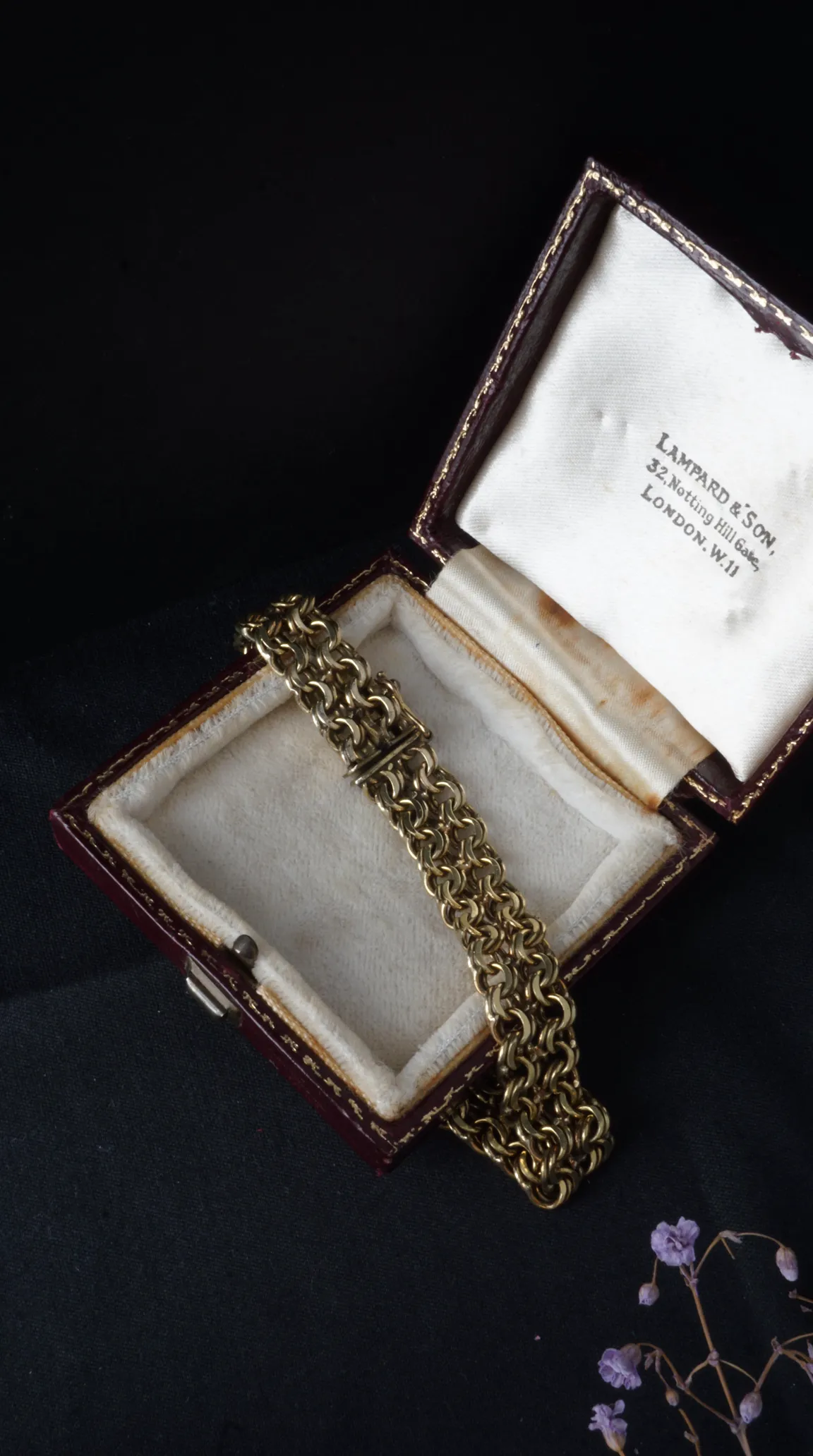 Vintage gold fancy link chain bracelet, possibly Victorian or Edwardian, resting in an antique red leather Lampard & Son jewelry box with cream satin lining.