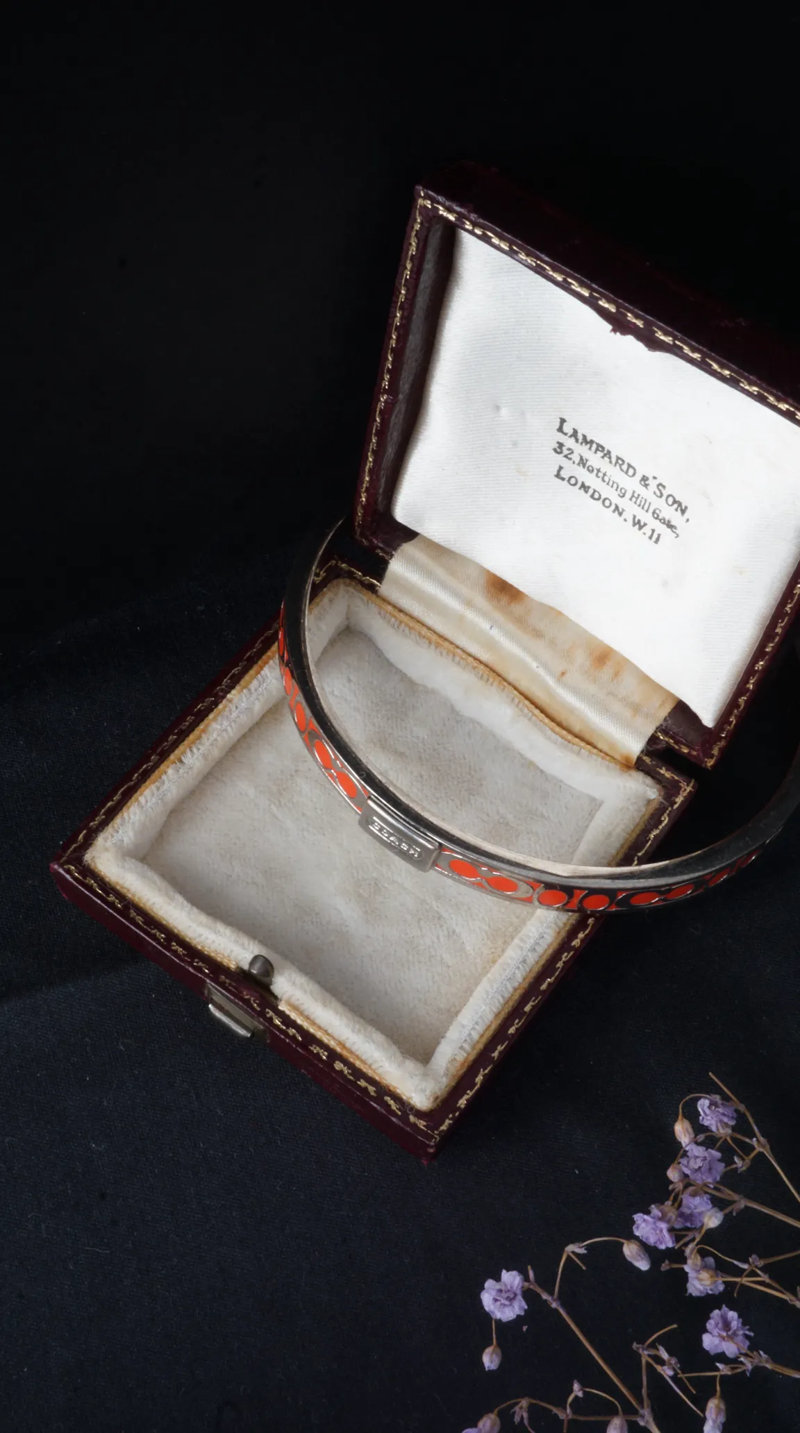 Vintage Coach silver-toned bangle bracelet with orange enamel geometric pattern, in antique Lampard & Son London jewelry box.