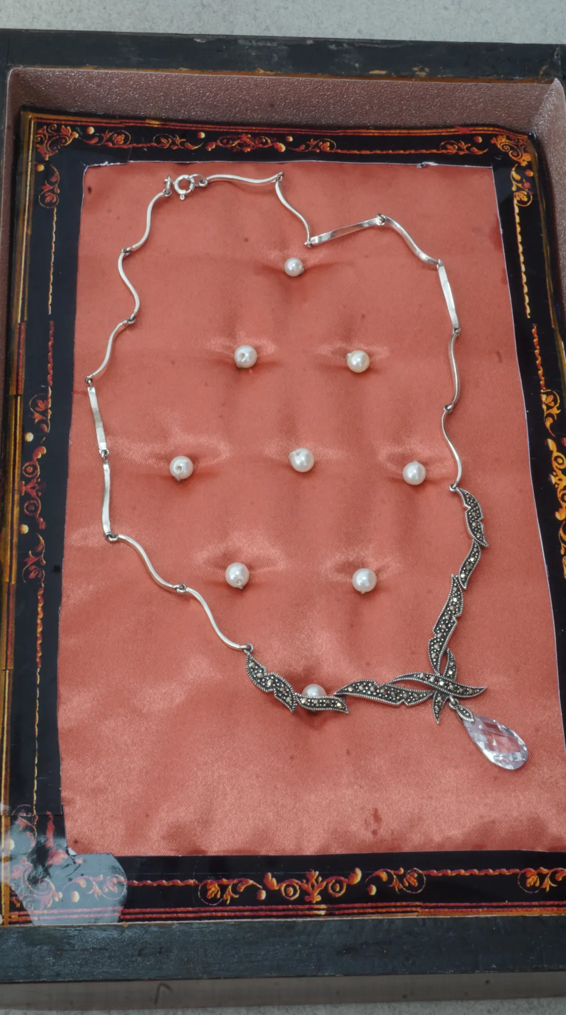 Vintage silver marcasite necklace with clear crystal teardrop pendant and pearl on pink satin.
