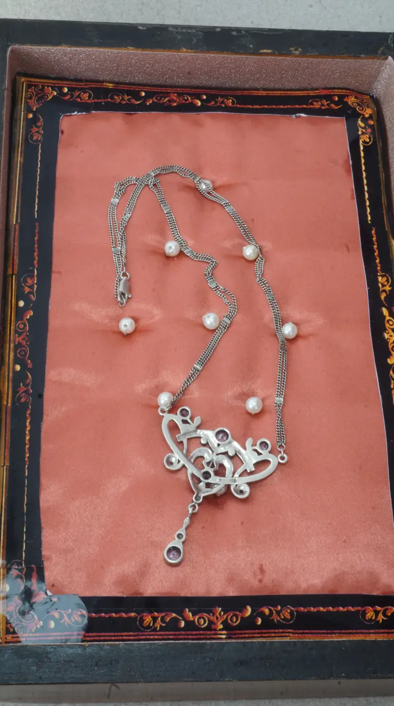 Vintage silver multi-strand necklace with scattered pearls and ornate purple gemstone pendant.