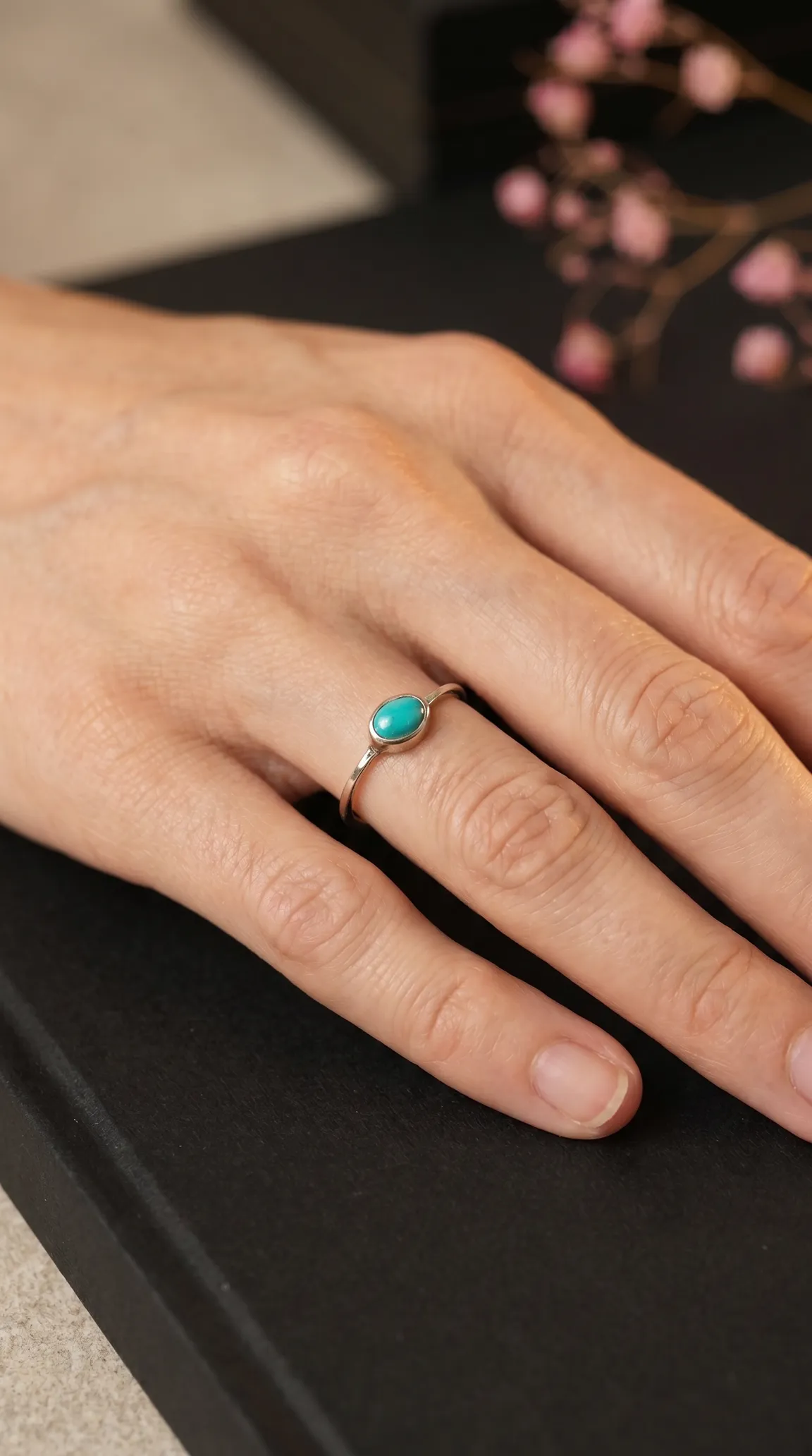 Dainty vintage sterling silver oval turquoise ring on a woman's hand