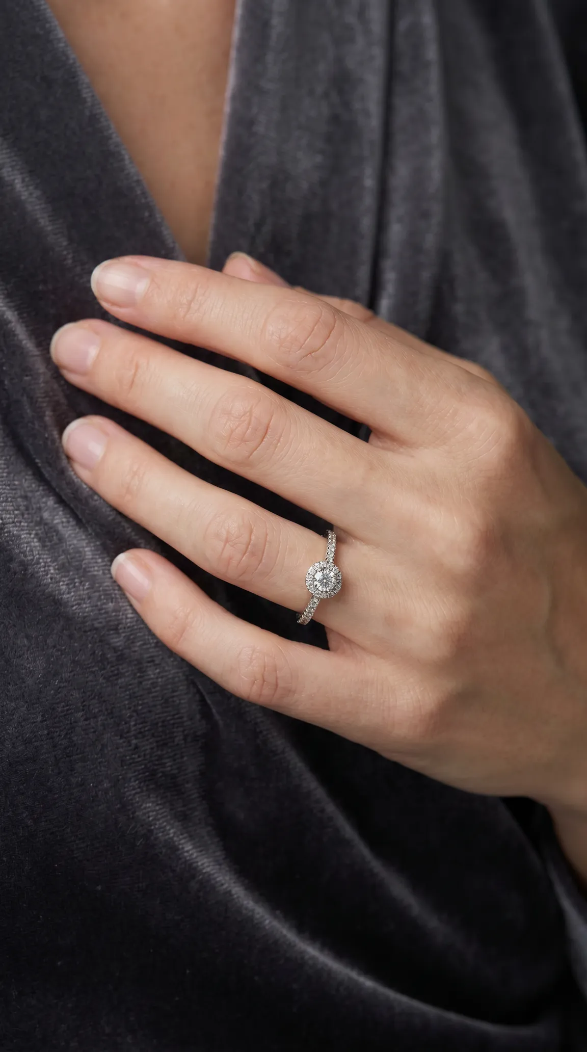 Vintage diamond halo engagement ring with pavé band, white gold antique jewelry on a woman's hand.