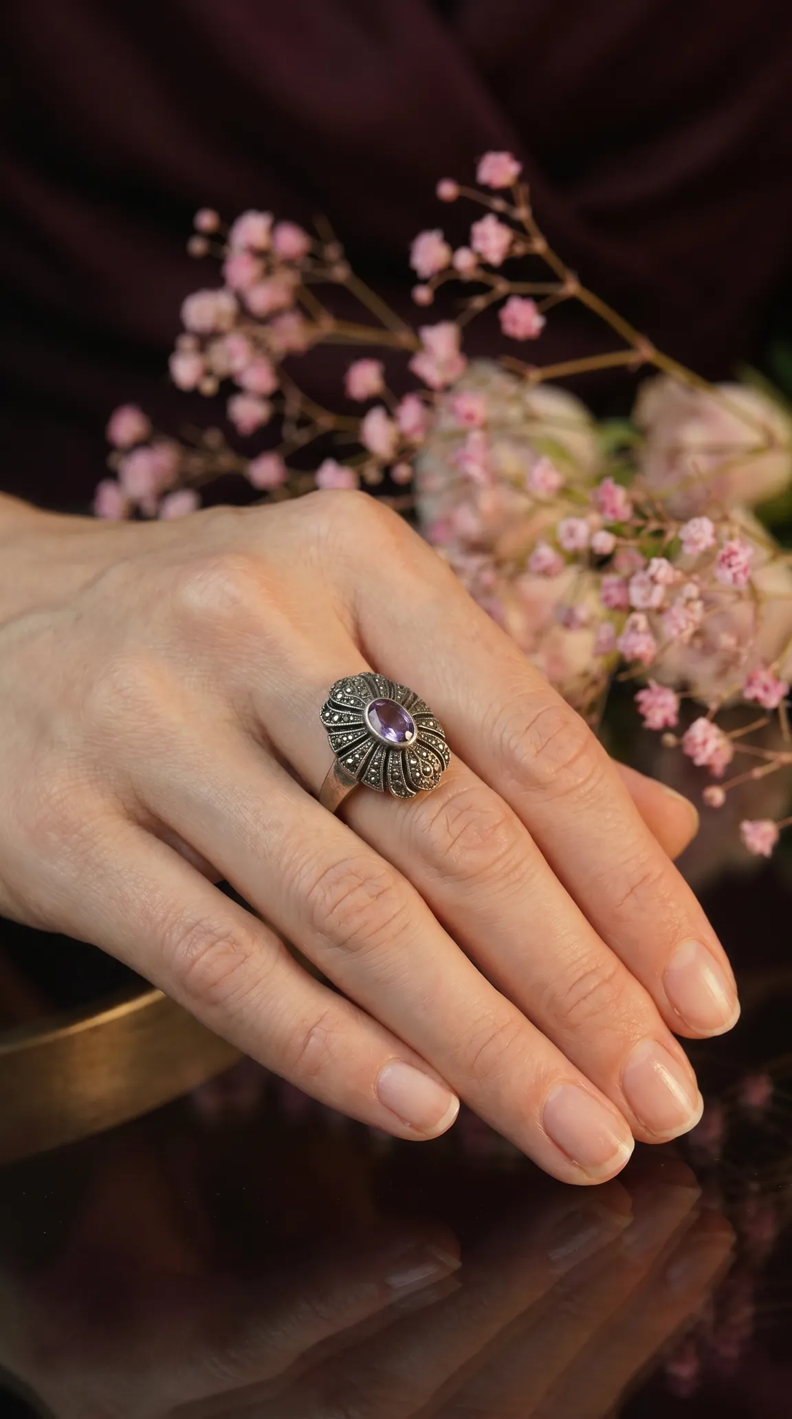 Vintage sterling silver amethyst and marcasite oval ring on woman's hand