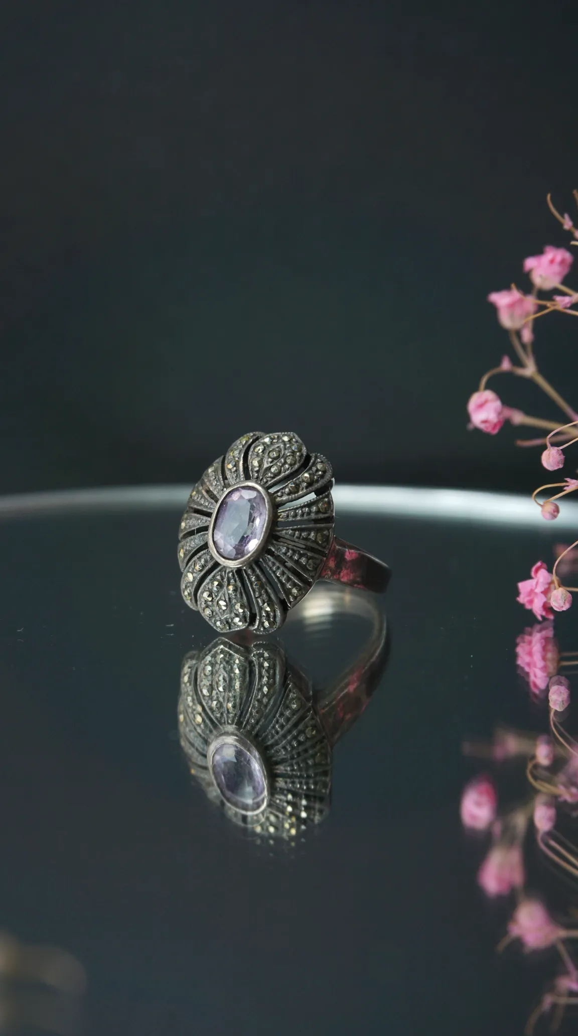 Vintage silver marcasite ring with oval amethyst gemstone, ornate radiating design.